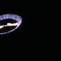 Une soucoupe volante éclairée par des Led et emportée par un hélicoptère