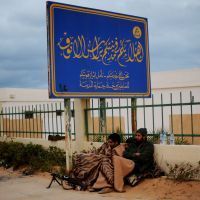 Combattants libyens sous un panneau annonçant la bienvenue en Libye